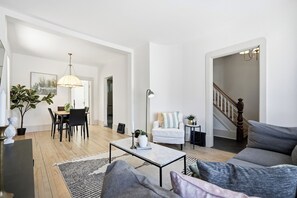 Ein geräumiges Wohnzimmer mit Essbereich, einer Treppe und Blick ins Freie.