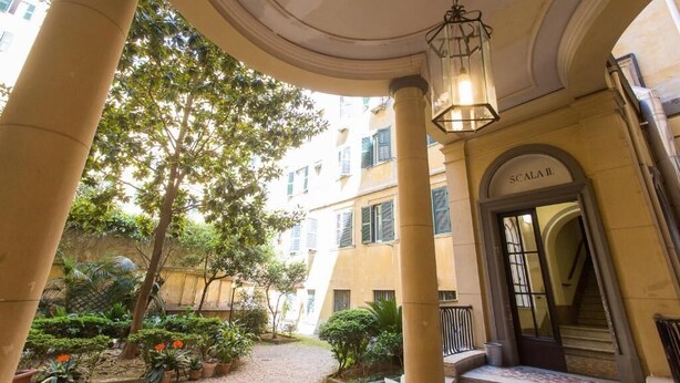 A courtyard with columns, a staircase, and a building entrance labeled 'SCALEA'. - Roman Holiday Home Re di Roma (Rome)