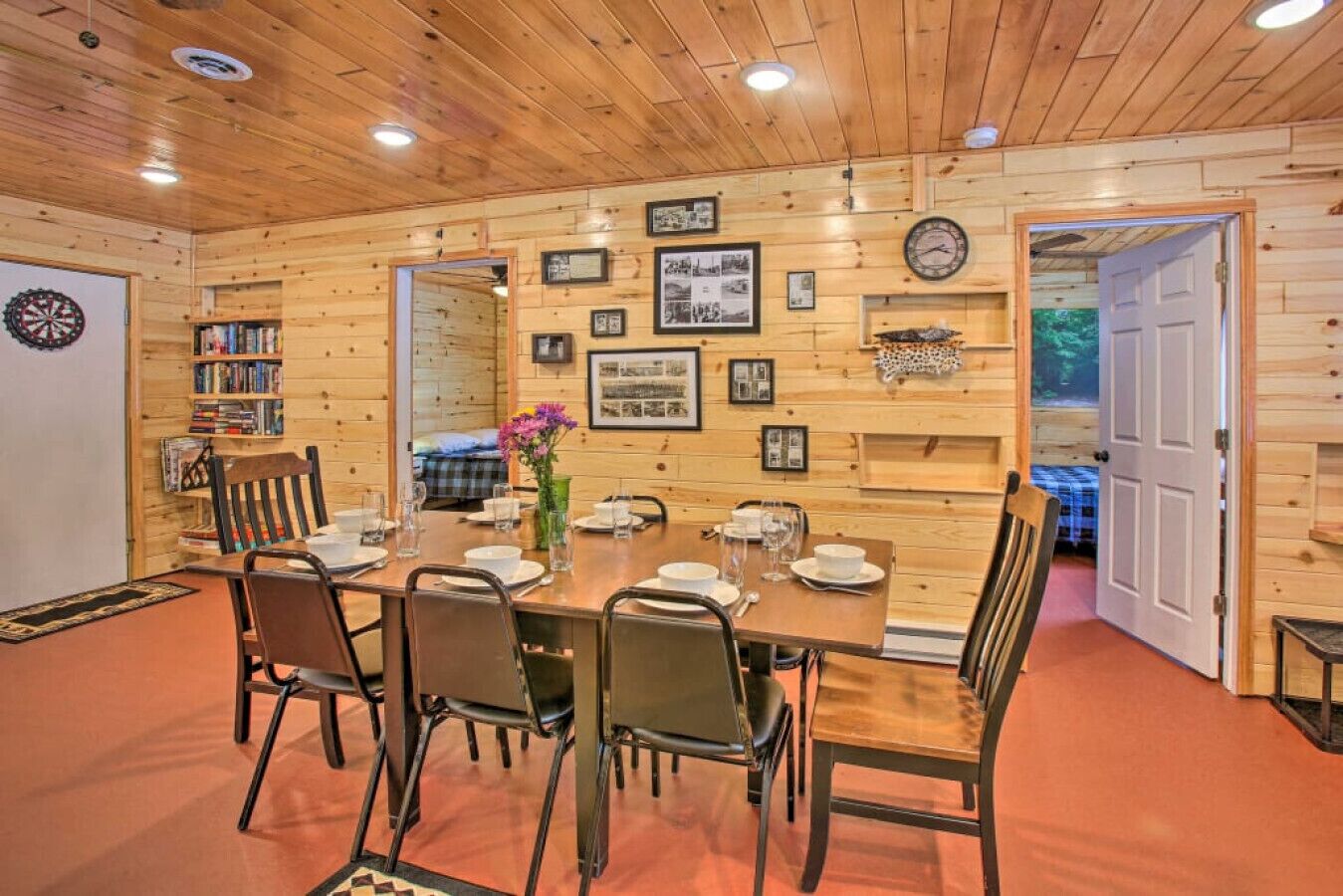 A dining area with a wooden table set for four, surrounded by chairs.