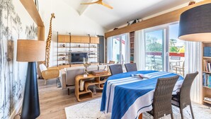 Un soggiorno moderno con un letto grande, un'area pranzo e una TV.