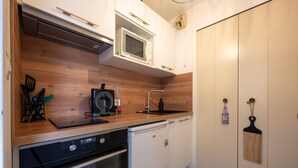 Eine kleine Küche mit Mikrowelle, Geschirrspüler und einer Holzausziehtafel.