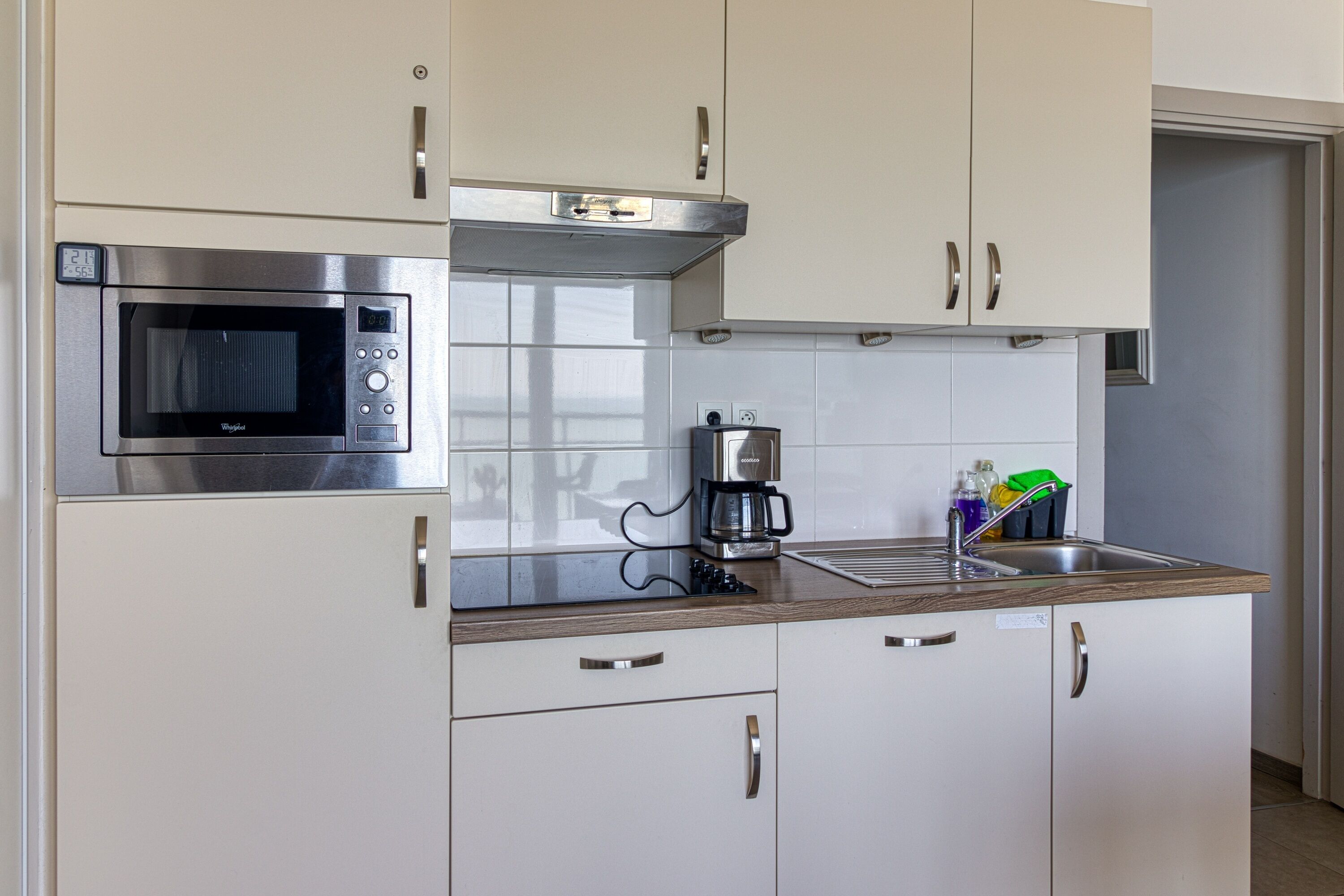 A modern kitchen with stainless steel appliances, a coffee maker, and a sink.