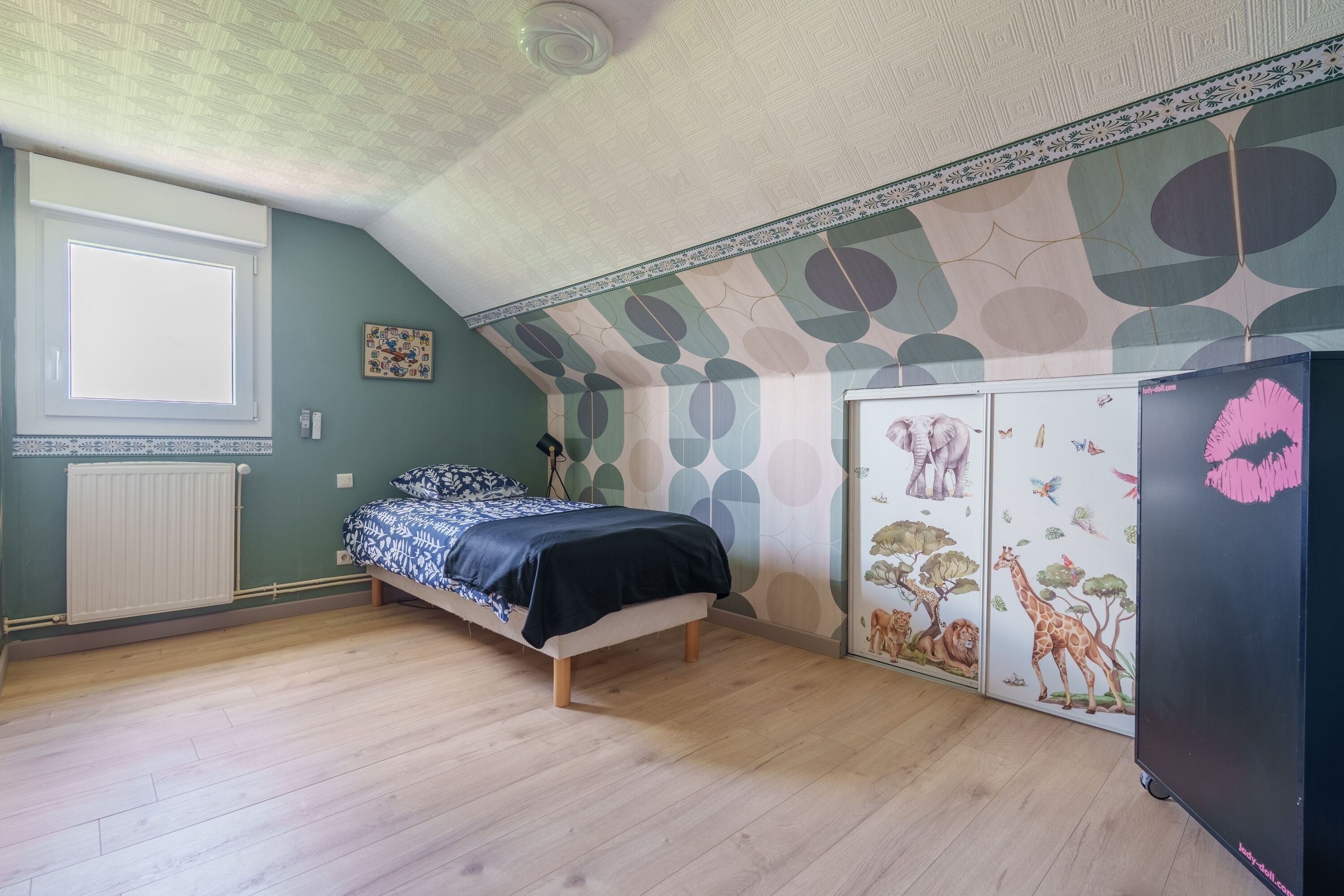 Un dormitorio con cama, radiador, armario y una pared con diseño de hojas.