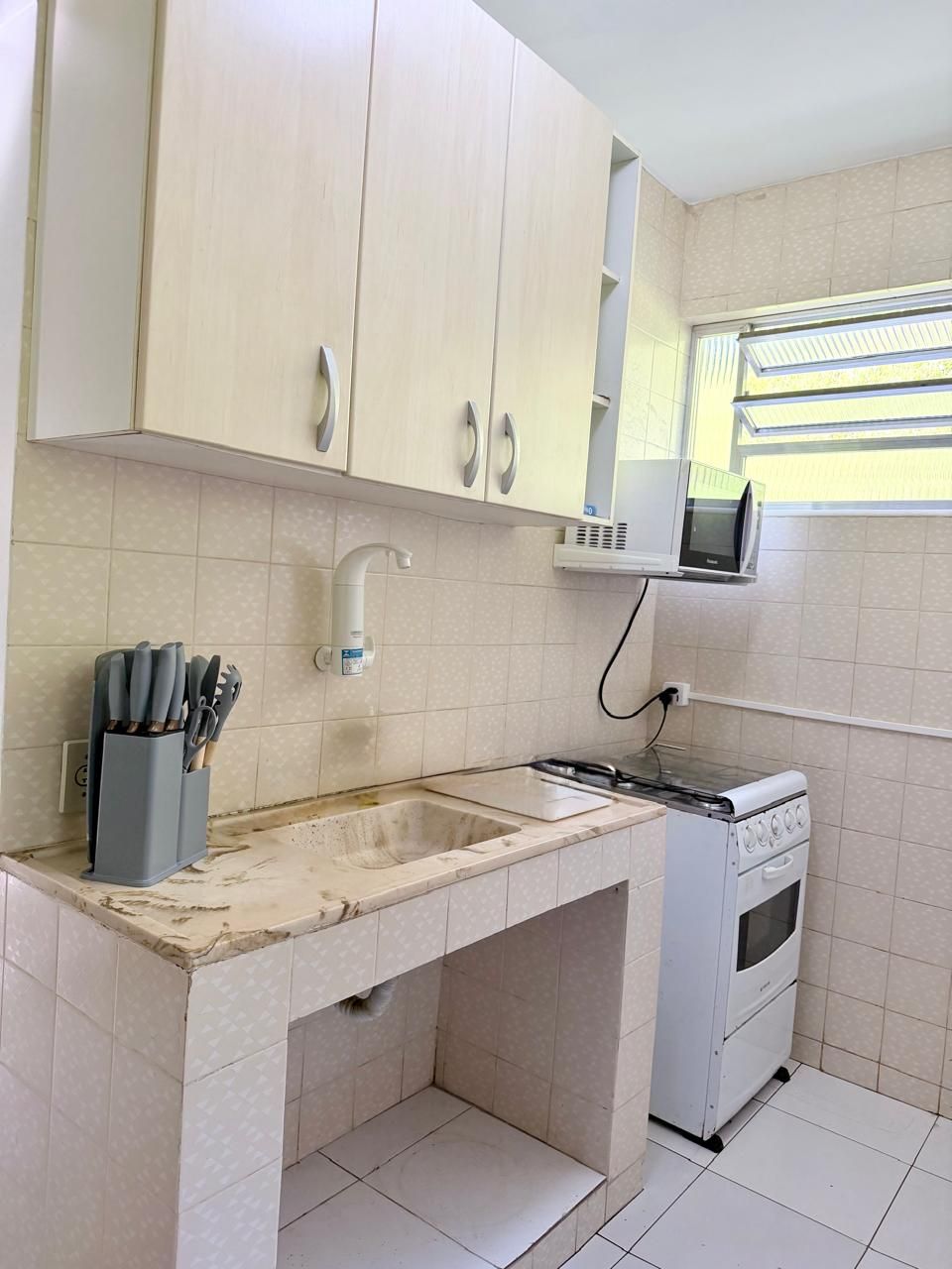 Una cocina con mostrador, pileta, horno y alacenas.