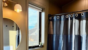 A bathroom with a sink, toilet, and a window with a view. - Cozy Luxe Cabin w/Hot Tub, Fire Pit & Stunning Views (Bozeman)