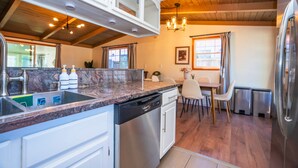 A kitchen with a dishwasher, a sink, and a dining area with chairs and a table. - Central 3BR 2BA Near Santana Row & Valley Fair (San Jose)