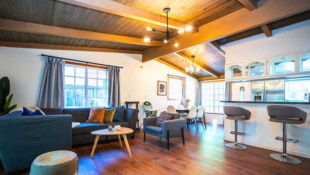 A modern living room with a sofa, ottoman, and two bar stools. - Central 3BR 2BA Near Santana Row & Valley Fair (San Jose)