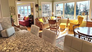 A spacious living room with a large window, a dining area, and a fireplace.