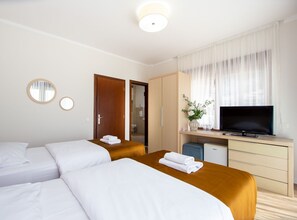 A hotel room with two beds, a TV, a desk, and a wardrobe. - Hotel Princ- Standard Twin Room 205 (Budva)