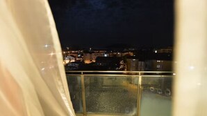 Ein Balkon mit Blick auf eine nächtliche Skyline.
