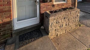 A brick house with a white front door, a window with a shutter, and a stone planter box. - Deaconess Gateway 3 miles, Quiet, Open, 1BDRM, Private Parking & More! (Evansville)