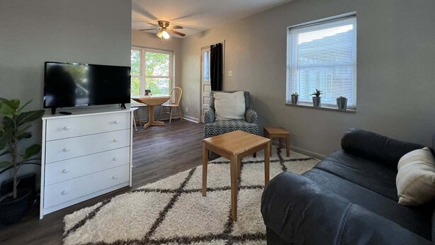 A living room with a TV, sofa, coffee table, and a dining area with a chair and table. - Deaconess Gateway 3 miles, Quiet, Open, 1BDRM, Private Parking & More! (Evansville)