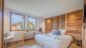 Ein Schlafzimmer mit Holzwand, einem Bett, einem Schreibtisch und einem Stuhl.