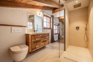A modern bathroom with a wooden vanity, a toilet, and a glass-enclosed shower. - Chalet, 350m from shops, 2nd floor, terrace, fireplace or stove, parking, tv, 200m², Combloux (Combloux)