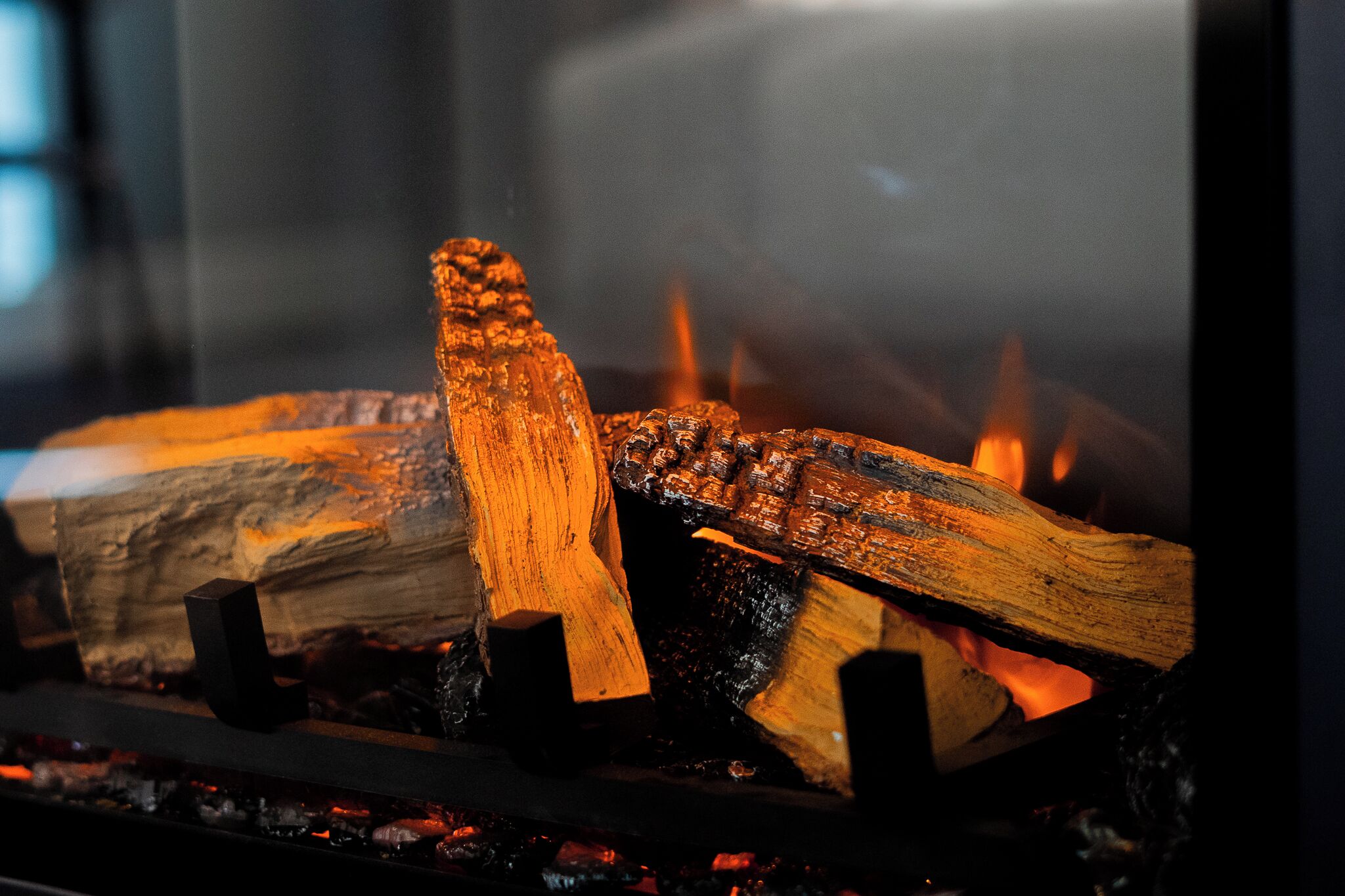 Gros plan sur des bûches de bois en train de brûler dans une cheminée.