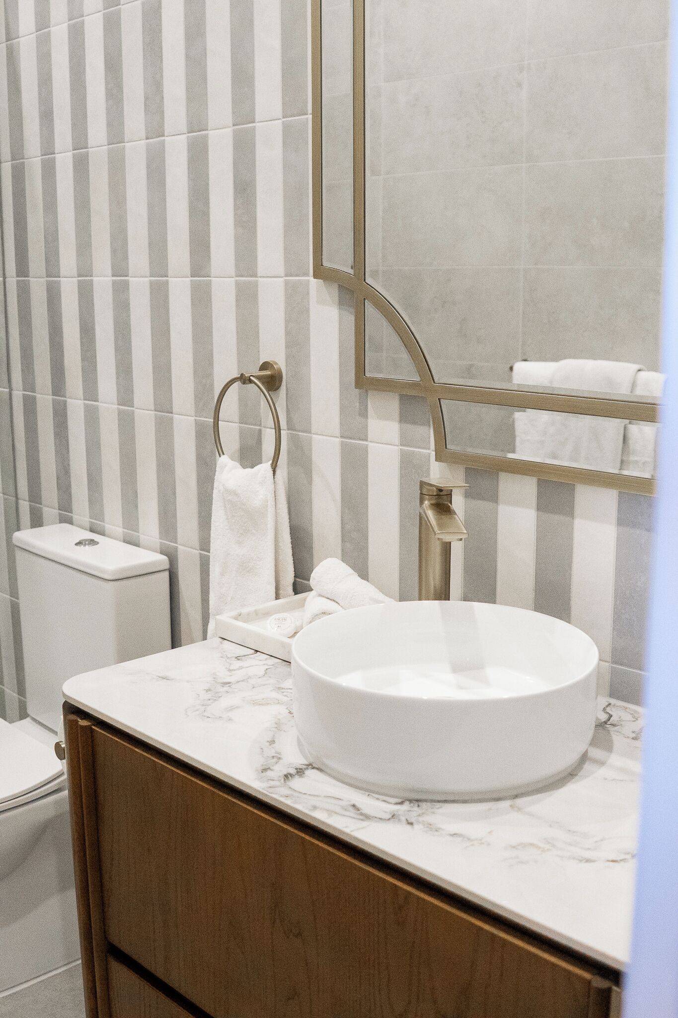Ein Badezimmer mit einem weißen Waschbecken, einer Toilette und einem Handtuchhalter.