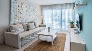 Ein modernes Wohnzimmer mit einer Couch, einem Couchtisch und Kunstwerken an der Wand.