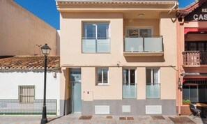 A two-story building with a balcony, a restaurant sign, and a logo for MAR Management. - Marina 2 Suites | Fuengirola (Fuengirola)