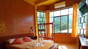 Una habitación con cama, escritorio, ventana con cortinas y ventilador de techo.