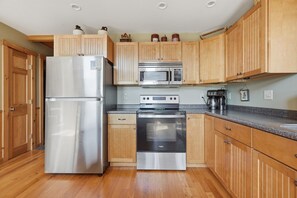 A kitchen with wooden cabinets, stainless steel appliances, and a granite countertop. - Lake View House with Hot Tub, Sauna and Game Loft (Woodstock)