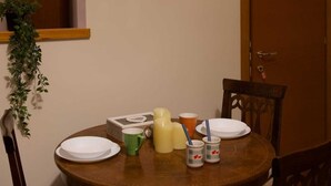 A dining table with chairs, a painting on the wall, and a door. - Vacation Home Sweet Angel 17, with view of Amphitheater (Sutri)