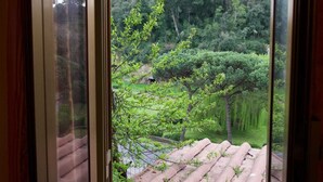 A window with a view of a garden with trees and a brick pathway. - Vacation Home Sweet Angel 17, with view of Amphitheater (Sutri)