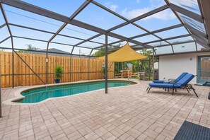 A covered outdoor swimming pool with a wooden fence, lounge chairs, and a yellow canopy. - 2BR2BATH Venice Poolside Retreat (Venice)