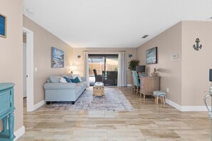 A spacious living room with a sofa, coffee table, and a view to the outside. - 2BR2BATH Venice Poolside Retreat (Venice)
