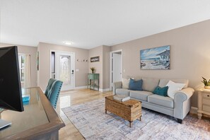 A living room with a sofa, coffee table, and a television. - 2BR2BATH Venice Poolside Retreat (Venice)