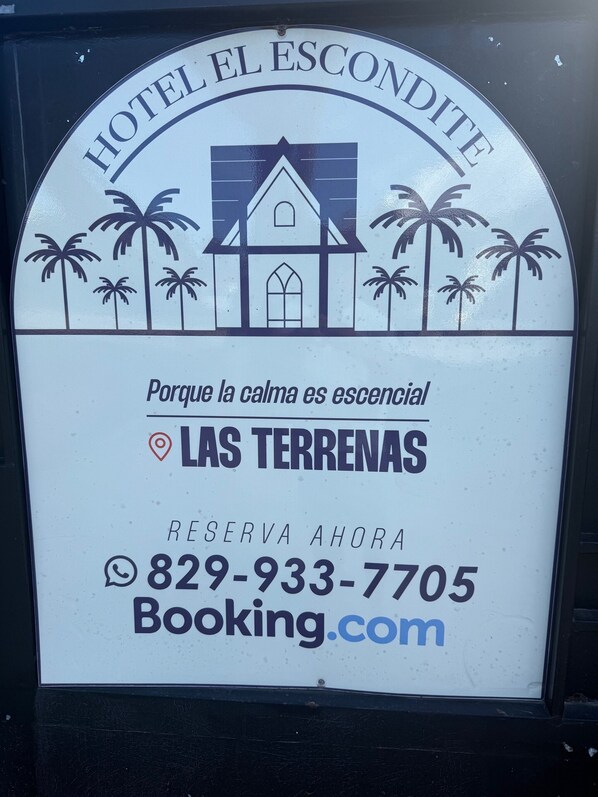 A hotel sign with a church and palm trees, indicating a tropical location.