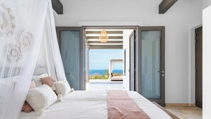 A bedroom with a bed, a view of the sea, and a balcony. - Kas Ubuntu - Villa with Panoramic Ocean Views (Kralendijk)