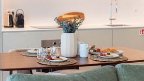 Ett matbord med tallrikar fyllda med mat, glas och en vas med gröna växter.