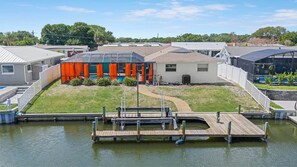 A residential area with houses, a swimming pool, and a dock over water.