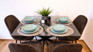 Una tavola da pranzo imbandita per quattro persone, con piatti, posate e tovagliette coordinati.