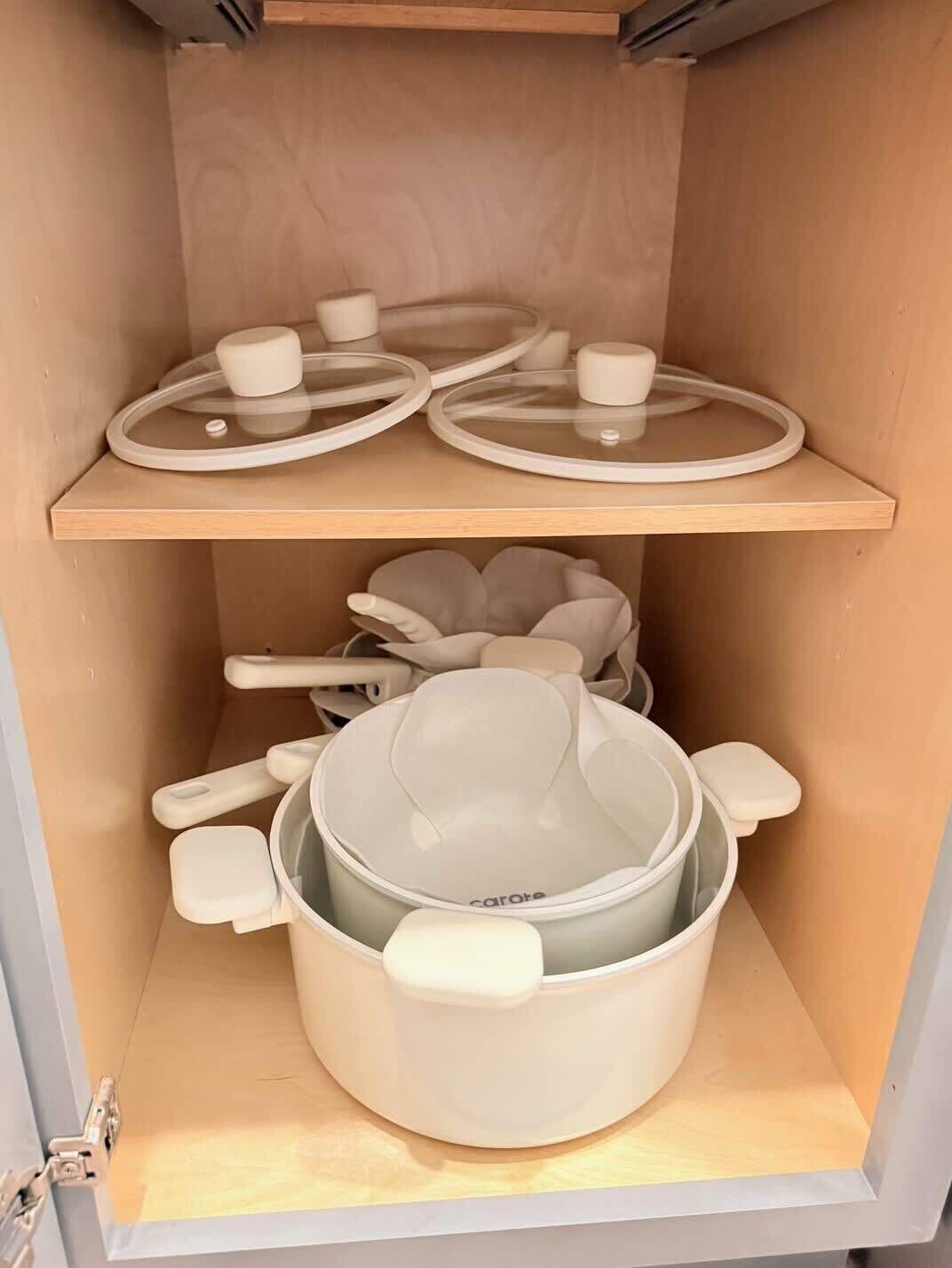 Un depósito con estanterías que contienen utensilios de cocina, incluyendo ollas, sartenes y platos de servir.