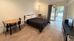 Une chambre à coucher avec un lit, un bureau, une chaise et une fenêtre.