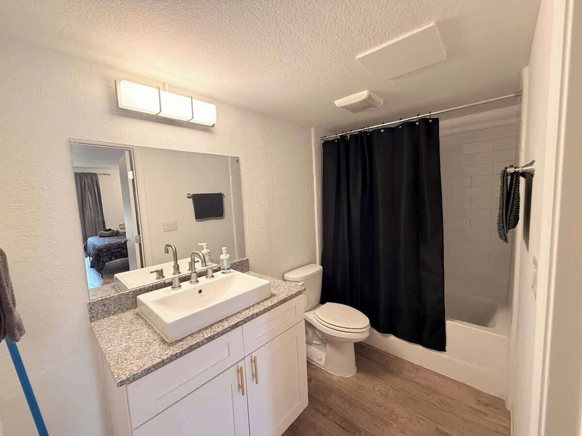 A bathroom with a white sink, a toilet, and a shower curtain.