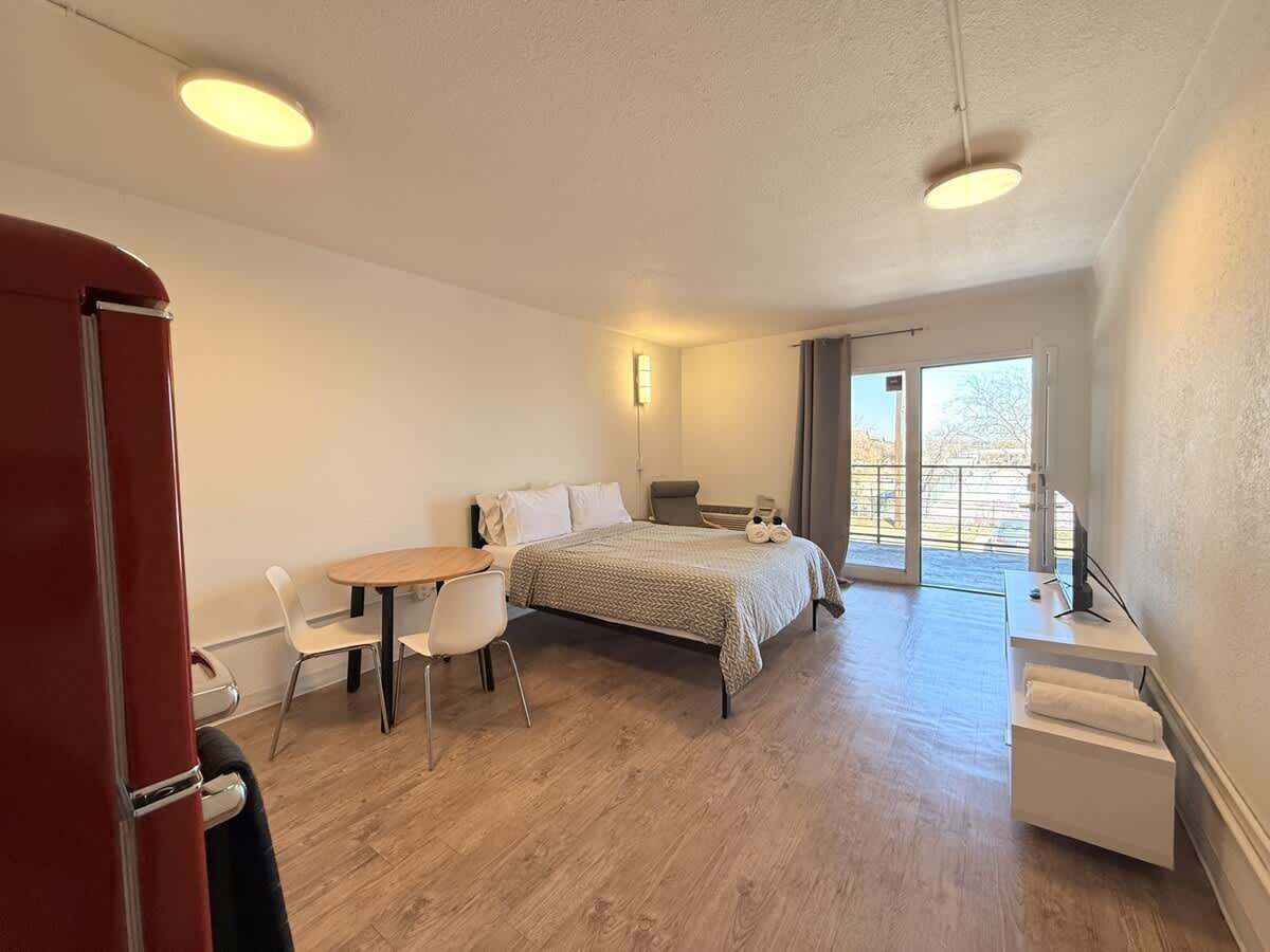 Une chambre à coucher avec un lit, un bureau, une chaise et une petite table.