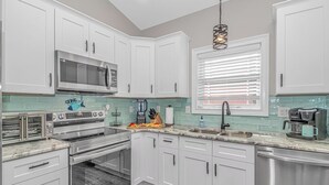 A modern kitchen with white cabinets, a built-in oven, a microwave, and a coffee maker. - N125:  Lakefront 3br/2ba Home in Ocean Lakes - "Sandy Cove" (Myrtle Beach)