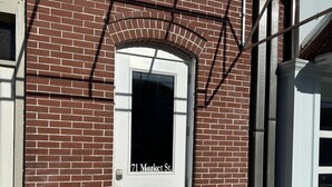 Ein Backsteinhaus mit einer weißen Tür, auf der '71 Market St.' steht.