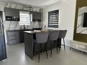 Eine moderne Küche mit Kochinsel, Barhocker und integriertem Mikrowellenherd.