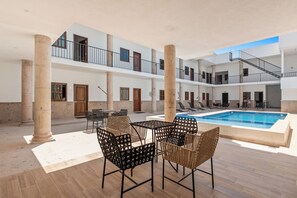 A multi-level building with a central pool, outdoor seating, and columns. - Casa Nacho Hotel by Monyxbnb (Puerto Vallarta)