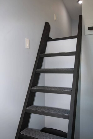 A black metal staircase with a handrail, leading to a landing. - Midnight Blue (Anderson)