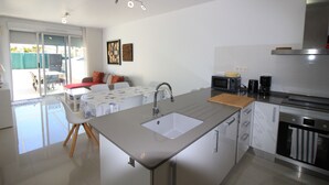 Una cucina moderna con isola centrale, forno a microonde integrato e cappa aspirante in acciaio inox.