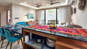 A modern dining area with a long table, blue chairs, and a colorful runner. - Casa Daniela  (Puerto Morelos)