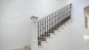 A staircase with a white handrail and black balusters, leading to a landing. - Spacious 4BR in Red Trails 30+ Day Stays (Washington)