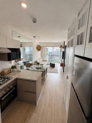 A modern kitchen with a central island, a built-in oven, and a stainless steel refrigerator. - Modern apartment with panoramic views, on the corner of San Isidro Street and just steps from the Costa Verde (Lima)