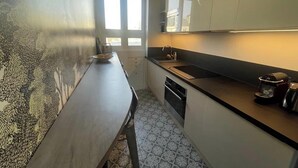 Una cocina compacta con una encimera larga, un fregadero y una cafetera.