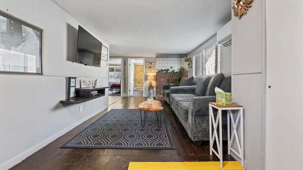 A modern living room with a sofa, TV, and a small table. - Beach Cottage w Hot Tub & Screened Porch! (Old Orchard Beach)