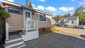 A single-story mobile home with a front porch, a small set of steps, and a mailbox. - Beach Cottage w Hot Tub & Screened Porch! (Old Orchard Beach)